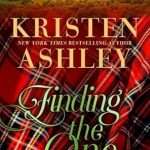Cover has lots of red-based tartan in the bottom 2/3 of the cover with the title and author name in cursive over the top and at the top of the cover is an image of a castle/manor house at sunset surrounded by woods